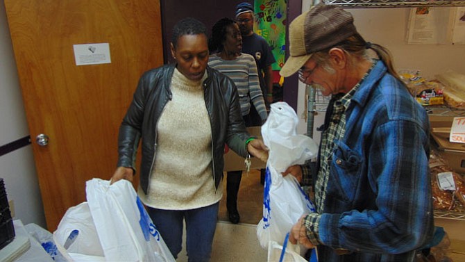 Rising Hope Food Pantry Manager Melissa Lee assists Ray Schonasky of Mount Vernon with his bags of food. 