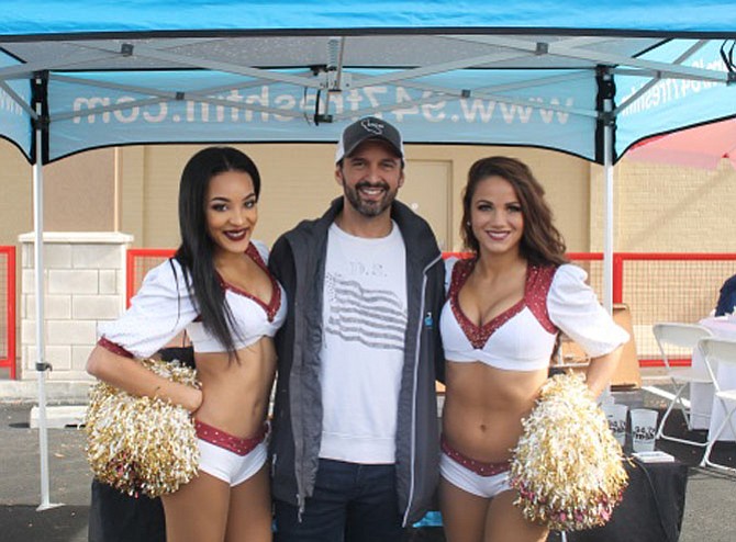 Radio personality Darik Kristopher with Washington Redskins cheerleaders at the Nov. 4 grand opening of Floor & Décor on Eisenhower Ave.