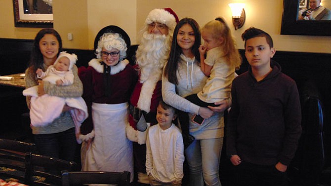 Faith, Melina, and Moe Hamdan, Jaida and Alex Garcia, and Sadie Garrett of Springfield with Santa and Mrs. Claus.