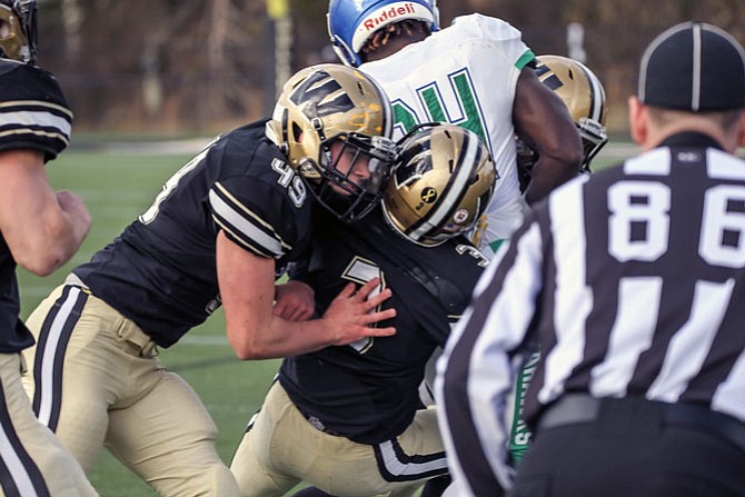 Dylan Winesett #49 and teammate Saadiq Hinton # 3 work together to stop South Lakes RB Albert Mensah #24.