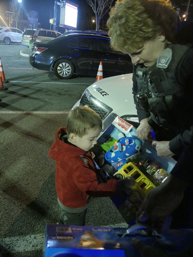 Three-year-old Alex Pollack pushes the red button to show off the beep on his donated airplane before he hands it over to Corporal Beth Lennon.