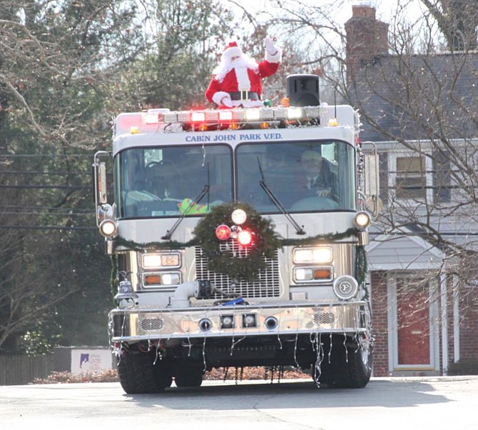 Santa waves from a Cabin John Park Volunteer Fire Department fire truck.