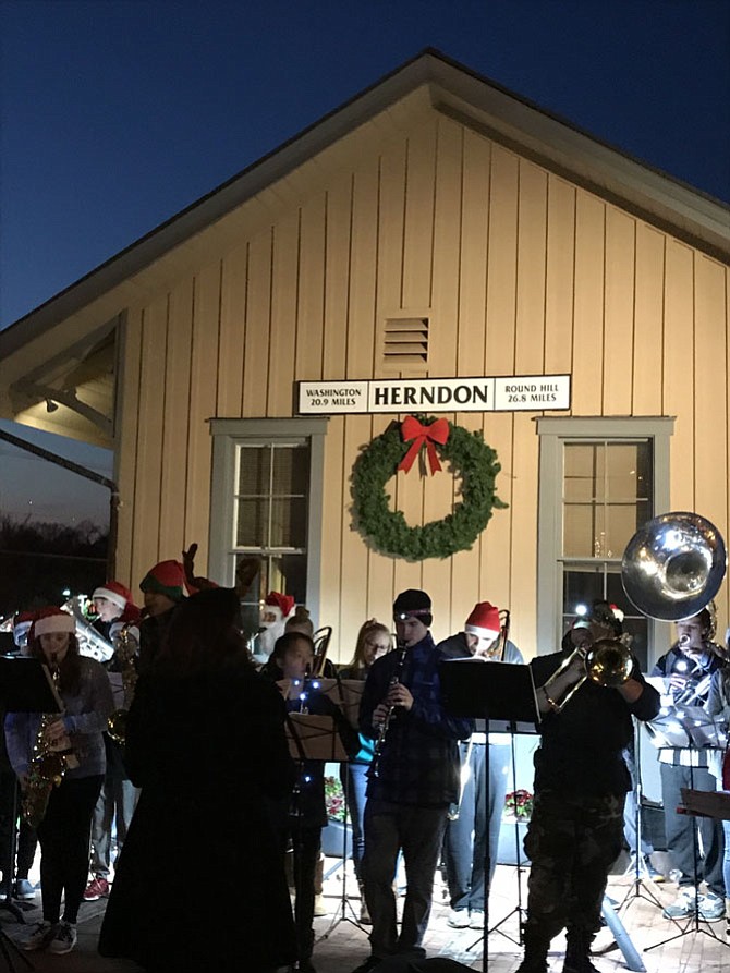 Members of the Herndon High School Band don Santa hats as they perform during the Town of Herndon's Hometown Holidays Tree Lighting and Sing-Along held Saturday evening, Dec. 2.