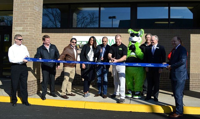 Karin Bensouda, owner and Mike Heath, general manager, prepare to cut the ribbon marking the opening of Launch Trampoline Park/Herndon, a new indoor sports and family entertainment facility. Daniel Flavin, CEO, Graceful Care (far left) and John P. Boylan President and CEO of Dulles Regional Chamber (far right) hold the ends of the ribbon while other local officials and staff at Launch Herndon look on. 