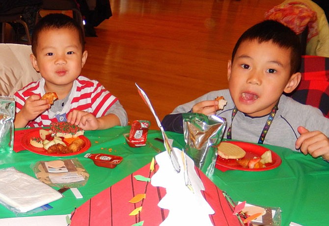 From left: brothers Marco Ye, 3, and William Ye, 5, munch on their lunch.