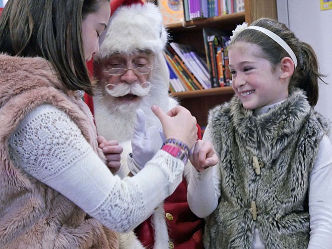 Cassie and Blaine Page hook pinkie fingers with Santa and promise never ever ever to fight with each other, at least until after Christmas.