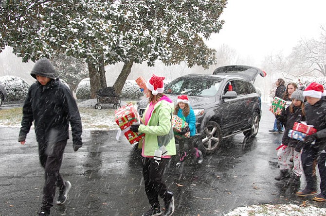 Snow falls as volunteers bring gifts to the Wish List Project drop-off Dec. 9. 