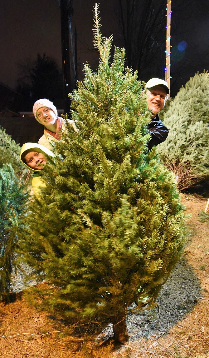 Tabitha, Austin, and Brandon Kidd choose their Christmas tree at the Cabin John Park Volunteer Fire Department Station.