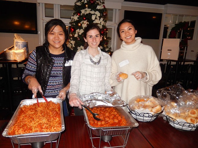 Serving up spaghetti, meatballs and rolls to the parents and children are (from left) FACETS volunteers Miranda Lan, Katie Plaster and Ngan Pham.