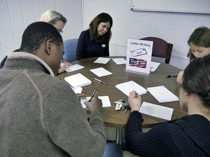 A table of participants are busy writing letters to active duty service men and women as one of the volunteer choices at Culpepper Garden on Jan. 15. Some of the other opportunities included purchasing items for welcome kits for Bridges to Independence families, cleaning up trash and debris with Arlingtonians for a Clean Environment and assisting with screening immigrants for Just Neighbors. 