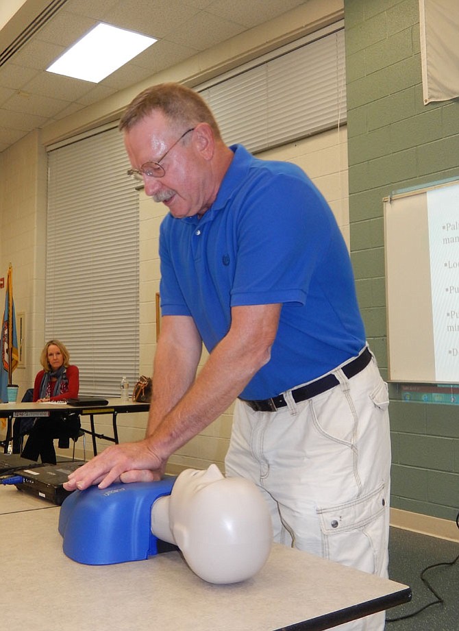 Demonstrating CPR, EMT/paramedic Gary Orski locks his arms and uses his upper-body strength and abdominal muscles to compress this mannequin’s chest.