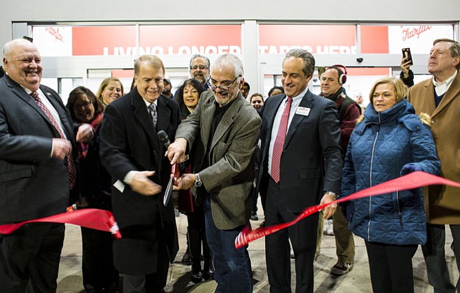 Mayor David Meyer (second from left) helps cut Earth Fare’s ribbon, Jan. 10, with company officials, plus City Council members Ellie Schmidt, Jennifer Passey, Michael DeMarco and Janice Miller, and City Manager Bob Sisson (at far right).