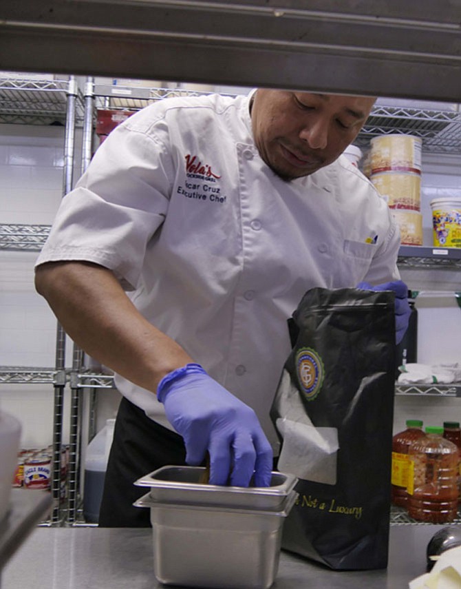 Chef Oscar Cruz picks a handful of golden raisins…