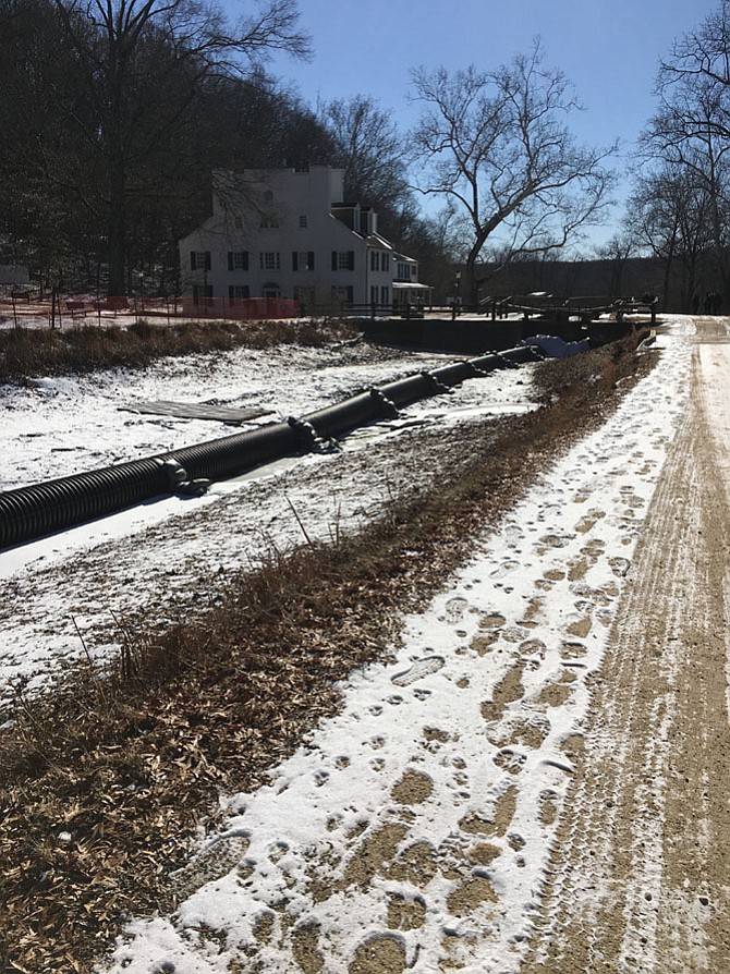 A pipe on the bed of the C&O Canal by Great Falls Tavern keeps water from filling the canal during construction.