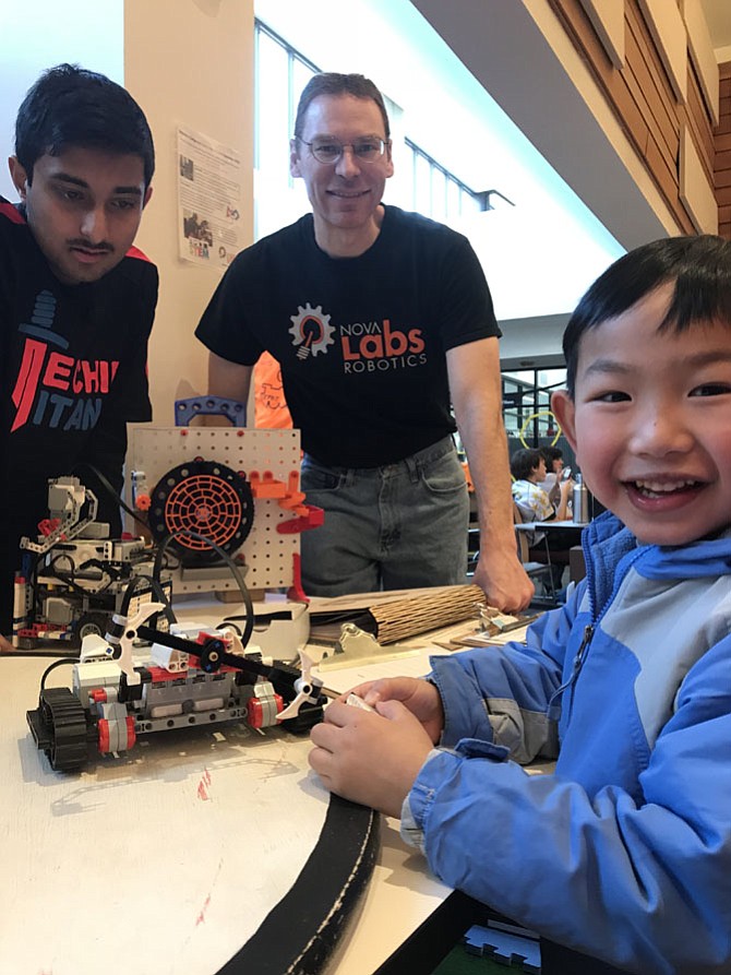 During the Reston Camp Expo 2018 held at Reston Community Center on Saturday, Jan. 27, 2018, Ryan Le, 5, of Wolf Trap tries out a “bot” created by makers at NOVA Labs. From left: NOVA Labs makers Sathvik Narayana, 14 of Centreville and Spencer Allain look on.