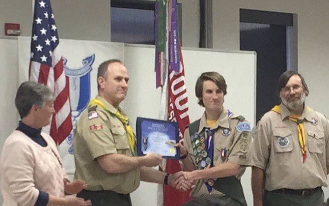 Michael Cohen, shaking the hand of Scoutmaster Kent Pankratz, is flanked by parents, Dawn and Don.