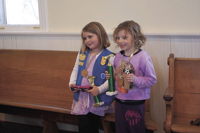 The winners are two young Daisy Scouts, from left: Hannah L. and Grace M. Hannah's pinewood car raced up to 194.0 mph while Grace's car travelled at 194.5 mph.