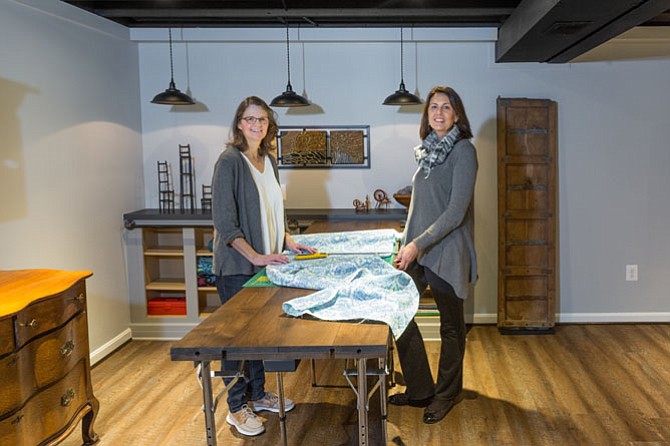 Fiber artist Shafer Dobry (left), with an assist from Dory Clemens of Foster Remodeling, demonstrates how her new custom-designed work table is used for cutting fabric. Dobry hired Clemens last year to help convert basement space into a fiber arts studio.
