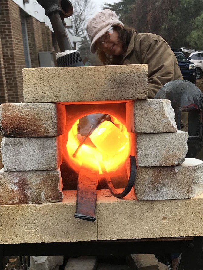 Amber Saunders heats a brick of metal at NoVa Labs in Reston until it glows a bright yellow-orange color, perfect forging heat. Saunders enjoys blacksmithing there with her son, Tyler, 16, and together they will attend Maker Faire NoVa in March.