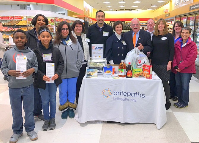 Members of Volunteers for Change, plus people from Fairfax County’s Coordinated Services Planning, help man the Britepaths donation table at Shoppers Food Warehouse. Directly behind the table are (from left) Sharon Bulova, Gerry Connolly, Scott Krinke and Christina Garris.