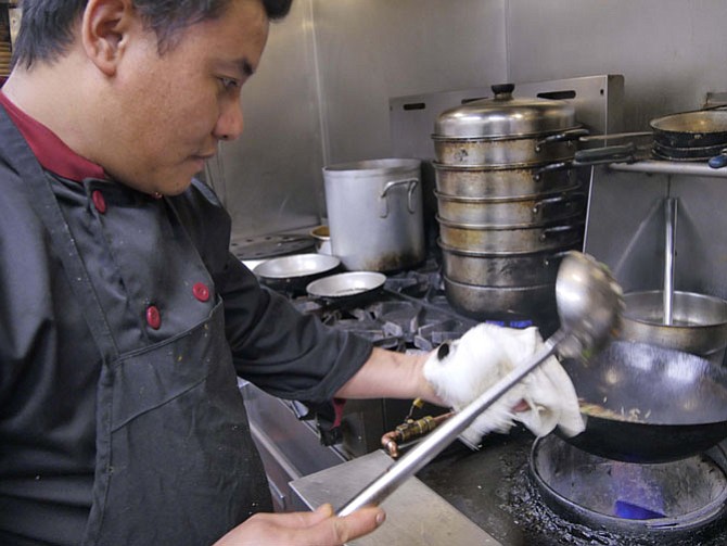 Chef Subash Rai sautés duck fat for an order of duck fried rice.