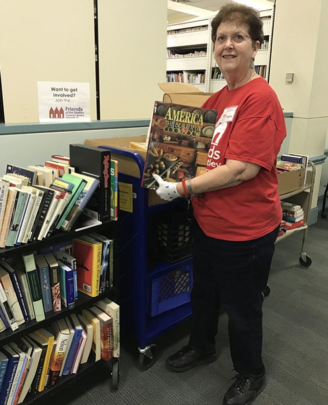 Nancy Blanton sorting books for this year’s spring book sale.