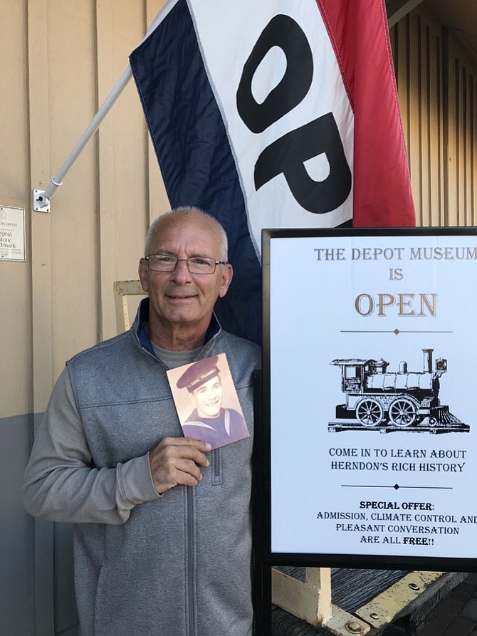 David Schmelz, son of a sailor who served during World War II aboard the destroyer the USS Herndon during the Invasion on Normandy, outside the Herndon Depot Museum holding his father's U.S. Naval Training photograph. The destroyer was named after Captain Herndon, namesake of the Town of Herndon.