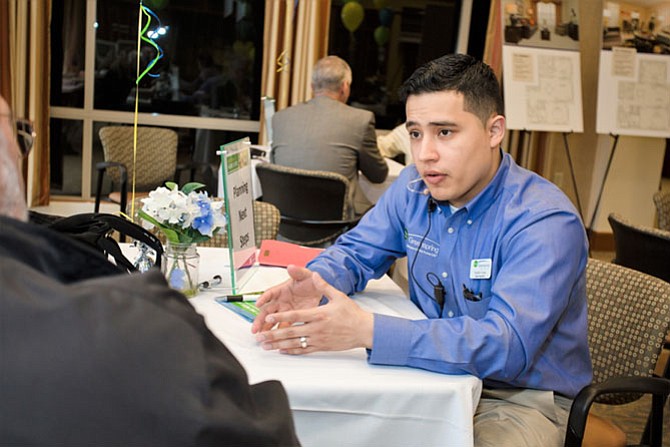 Franklin Funes speaks to a prospective Greenspring resident at a Sales event.