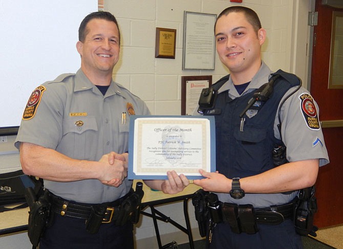 Assistant Station Commander Lt. Ryan Morgan (left) presents the Officer of the Month certificate to PFC Patrick Smith.