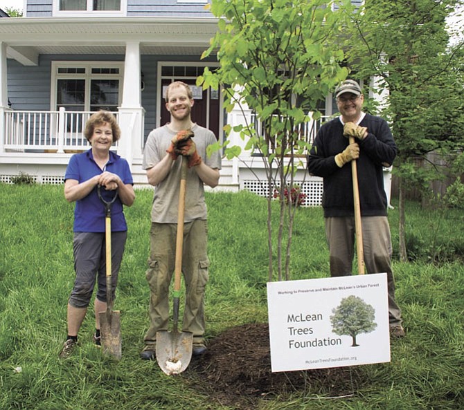 Homeowner Jason Kitson (center) plants a Redbud tree with MTF volunteers Carol Wolter and Ray Lewyckyj.