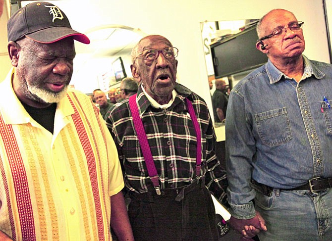 William Charity (center) leads the Barbershop Bible Study Ministry in song.