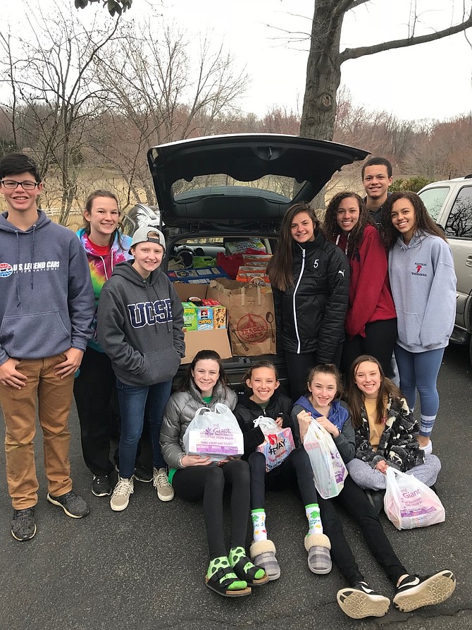 Great Falls teenagers fill the first of four cars with items collected for the Spring Break Food Drive.