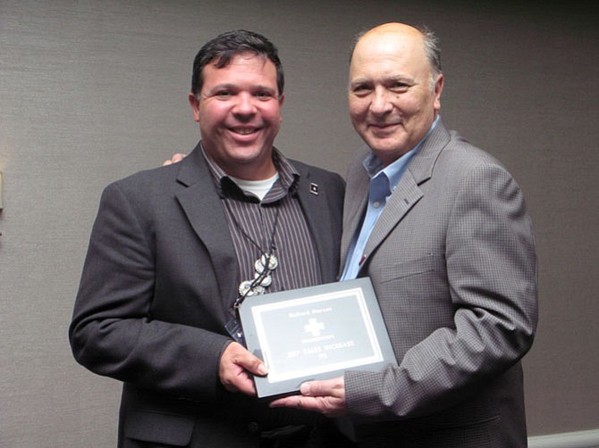 House Doctors of McLean owner Rich Marzan, left, accepts one of his awards from House Doctors President Jim Hunter.