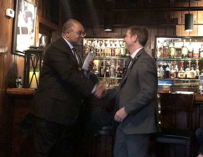 Deputy Chief Dave Huchler, right, is congratulated on his retirement from the Alexandria Police Department by former Police Chief Earl Cook, March 27 at Landini Brothers Restaurant. Huchler has been named the new Chief of Police for the Metropolitan Washington Airports Authority.