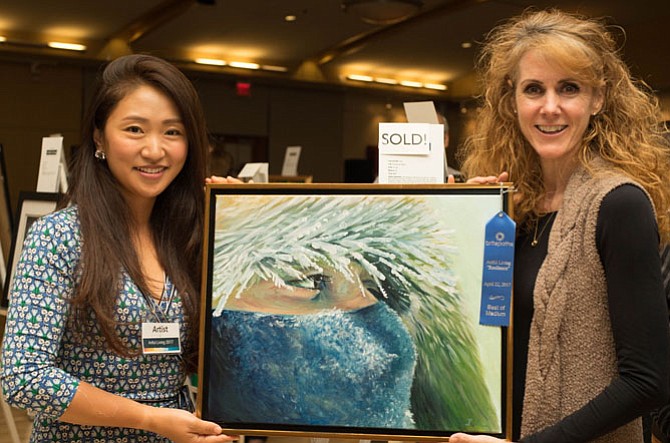 Artist Ire Lee (left) and Britepaths’ Board of Directors member Joni Henderson with Lee’s work, “Annapurna 26200,” at last year’s Artful Living event.