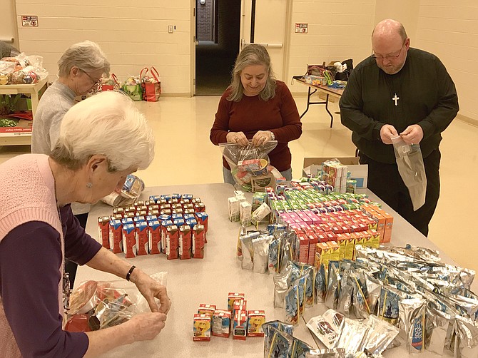 Community members helping prepare Power Packs of Food for Others.