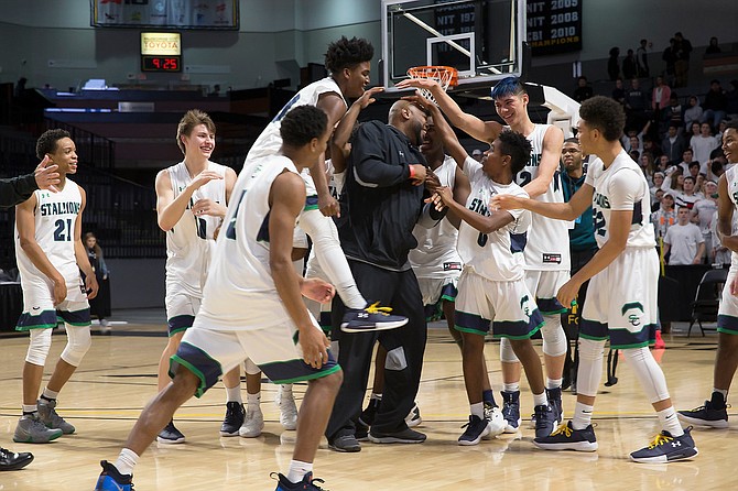 Mike Robinson, Head Coach of South County, is congratulated by his team on the court after their 63-47 6A State Championship win. Robinson was named Coach of the Year.
