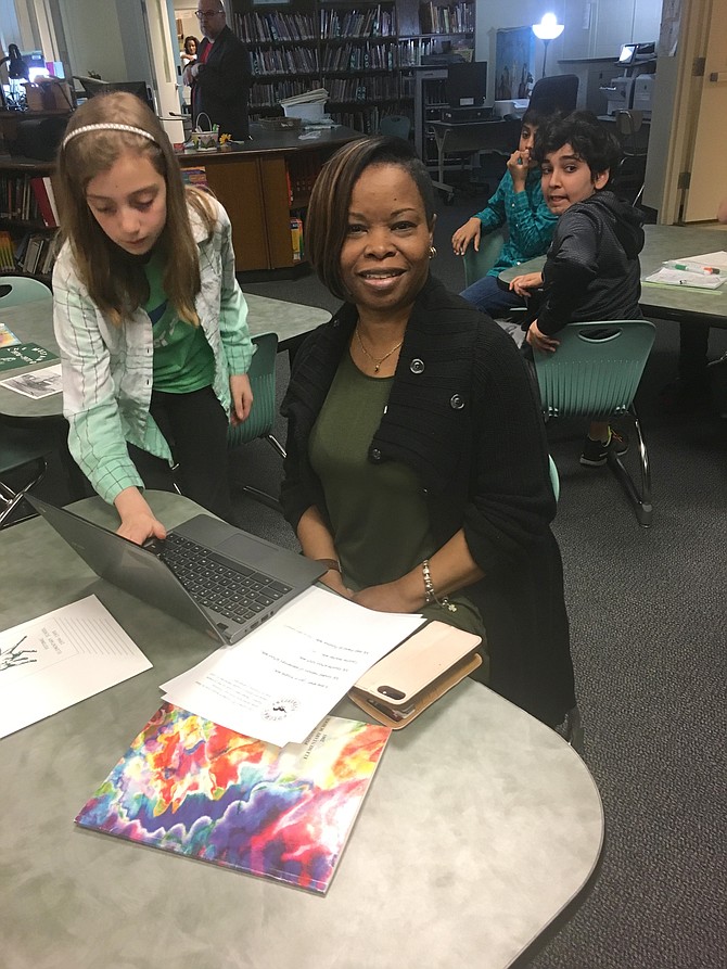 Former student Denise Jackson Johnson records her memories of Potomac Elementary School with the help of fifth grader Sarah Bland on Thursday, April 12.