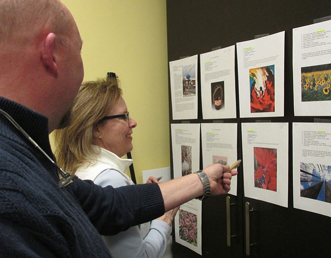 Event planning-committee volunteer Dennis Michael and Britepaths Development Assistant Debra Jones peruse the art submissions.