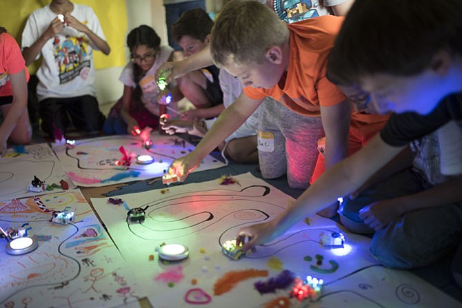 Children at Camp Invention create tracks for a self-driving robot. This camp has funding to sponsor low-income children this summer.

