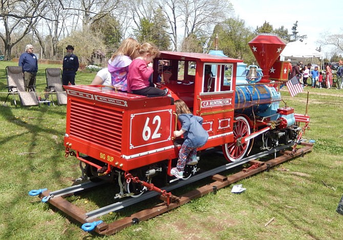 Children play on a toy train.