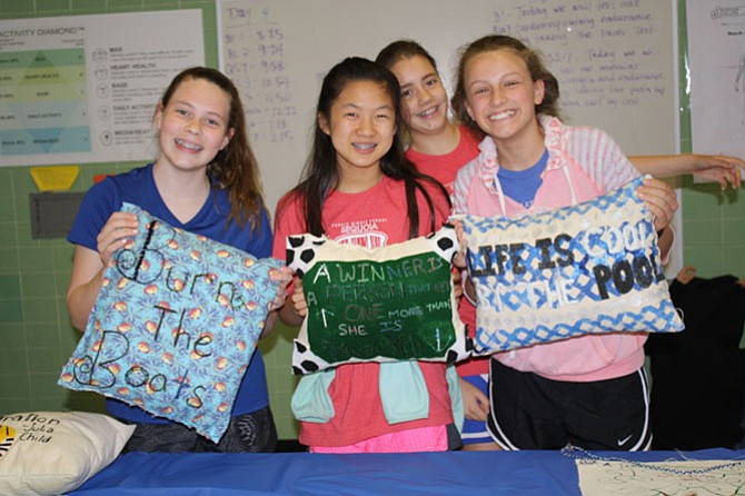 From left: Katie Mahony, Sabrina Chang, Leah Connell and Ellie Mcfadden showcase their stitched pillows that they have been working on for months to their friends and family.