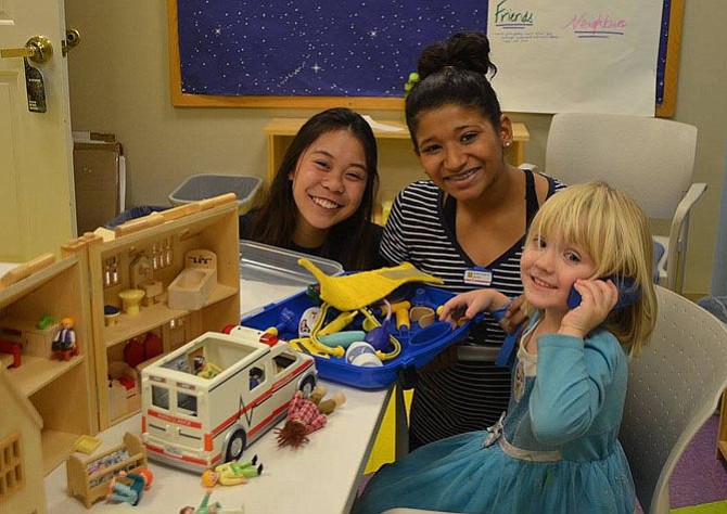 From left: Wildcats vs. Cancer club board members Liyandra Aranjuez and Sakina Lashkeri play with a childhood cancer patient at Inova Fairfax Hospital’s pediatric oncology education night.