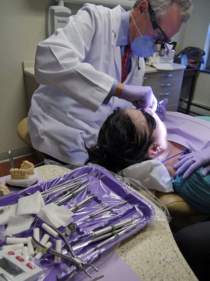 Dr. John Kling II numbs gums before removing temporary bridge.