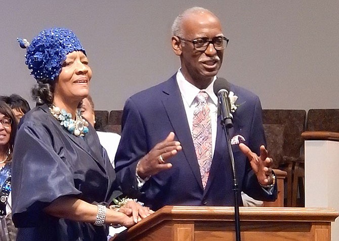 June Johnson stands beside her husband, the Rev. Eugene Johnson, while he addresses the congregation.