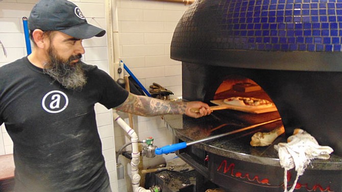 Pizzaiolo Neco Lopez prepares a Margherita pizza.