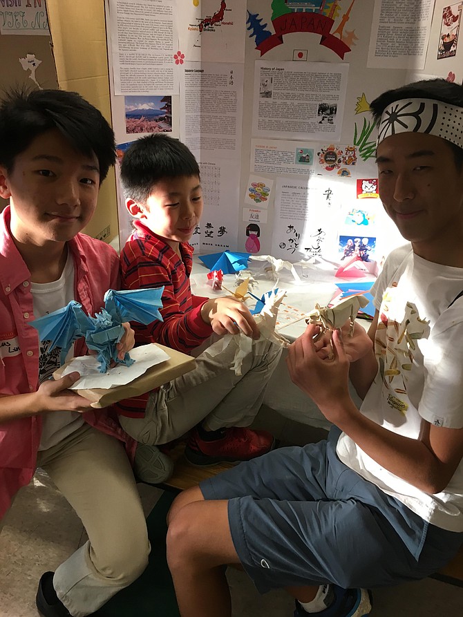 Lucas Lin, Ayden Yang and Raden Pak show off their origami creations at the Churchill High School Asian Festival Friday.