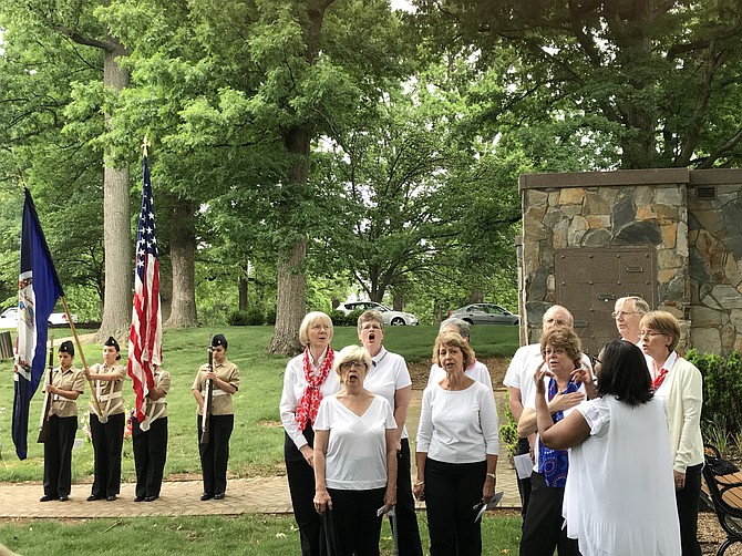 Members of the Herndon High School Navy Junior ROTC Detachment, Elisa Castro, Eleisa Cruz, Damaris Leva, and Isabel Palacios stand at attention as members of the Reston Chorale sing the national anthem.