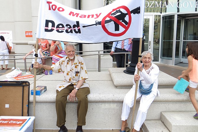 Robert Pallansch (left) and Marielouise Pallansch carrying a sign made by their son, Paul.