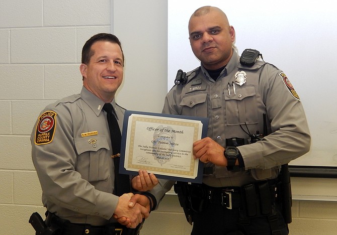 1st Lt. Ryan Morgan (left) presents the Officer of the Month certificate to Officer Taimur Mirza.